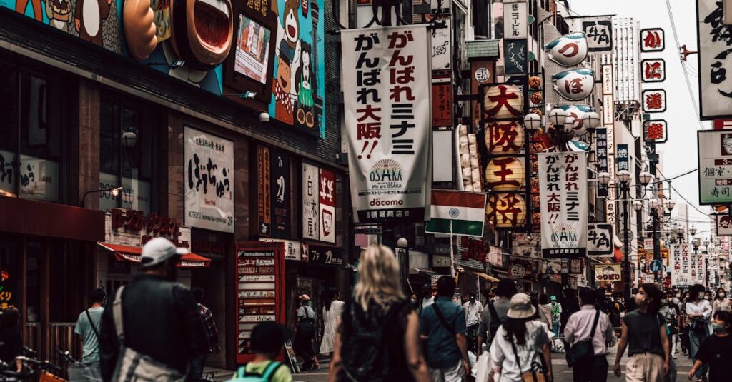 Vibrant shopping street in Osaka with people and colorful signs during day.