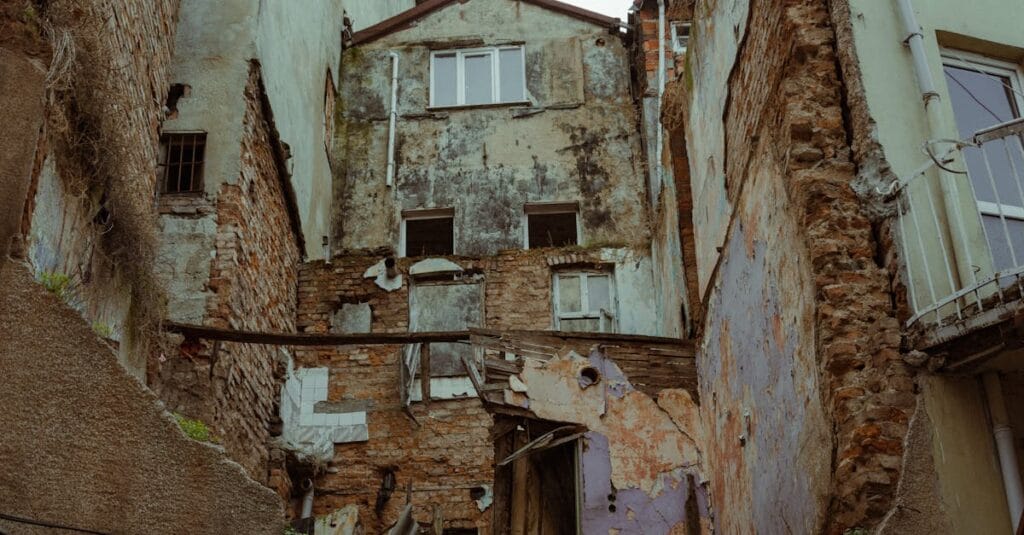 Low angle view of an abandoned building facade showcasing urban decay and weathered textures.
