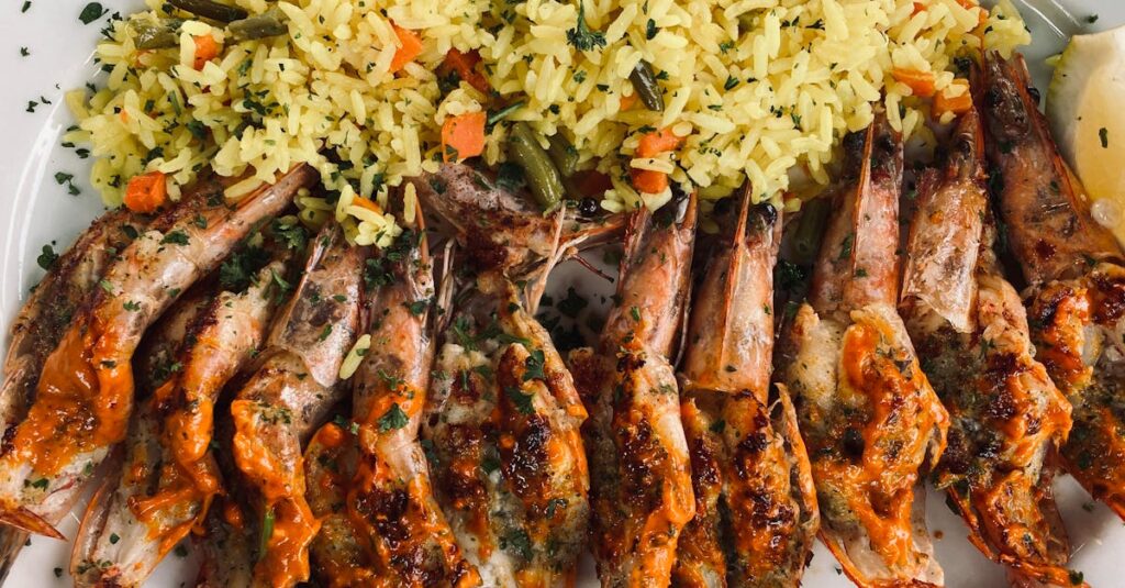 Delicious grilled prawns served with flavorful spiced rice on a plate.