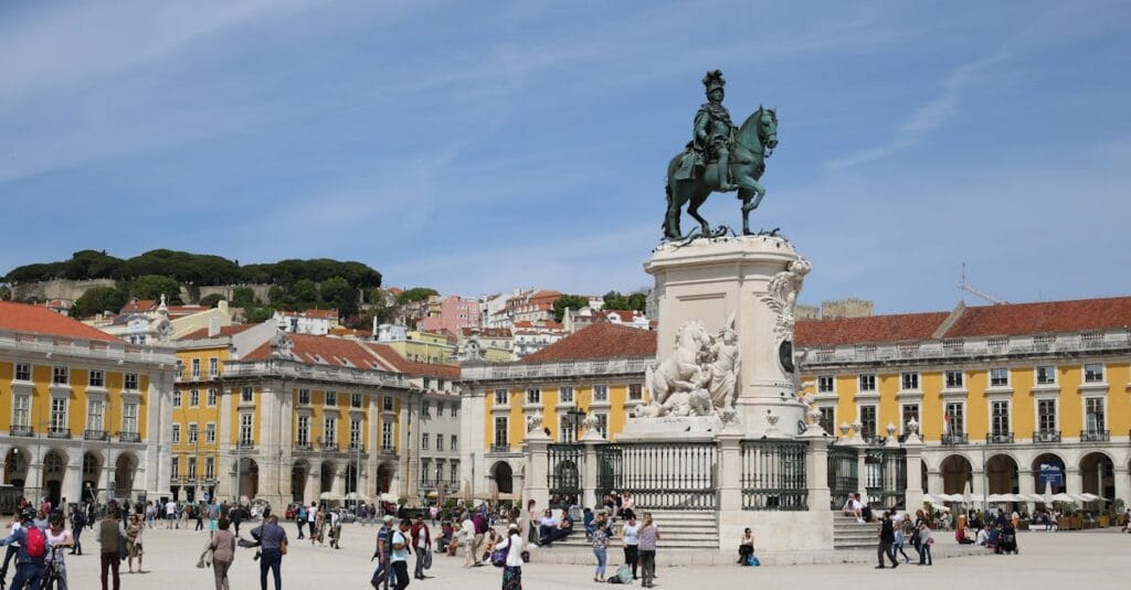 People enjoying a sunny day at the historic Praça do Comércio in Lisbon, Portugal.