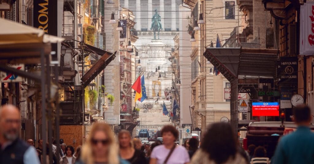 Bustling street in Rome with a view of the Altare della Patria and vibrant city life.