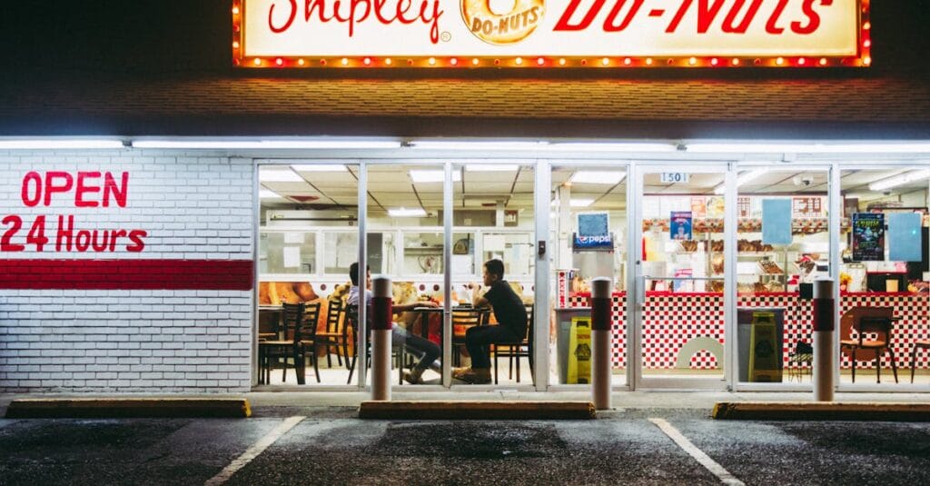 Brightly lit Shipley Do-Nuts shop in McAllen, TX, open 24/7. Nighttime urban scene.