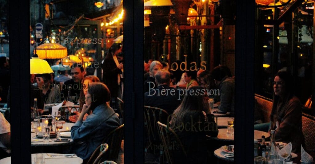 A vibrant café scene in Paris with people enjoying an evening at candlelit tables.