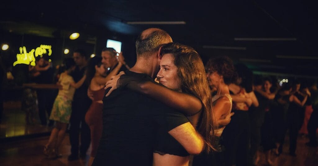 A captivating image of a couple dancing closely in a dimly lit nightclub setting.