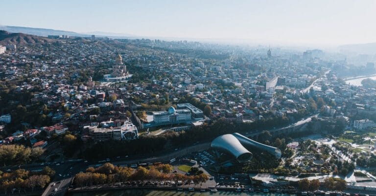 Capture of Tbilisi's cityscape showcasing landmarks and urban sprawl from above.