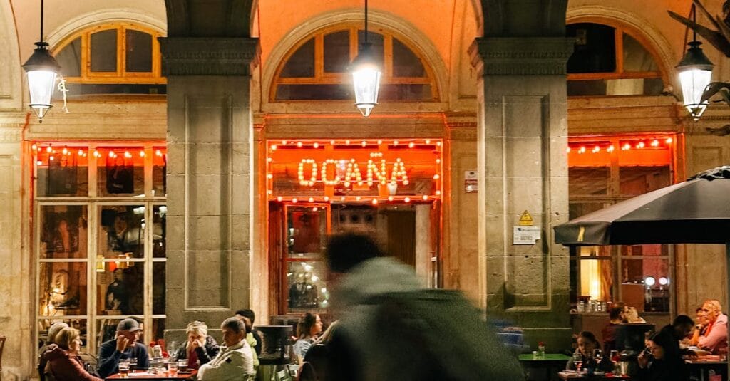 Vibrant street dining scene at Ocaña restaurant in Barcelona. Capture the lively evening ambiance.