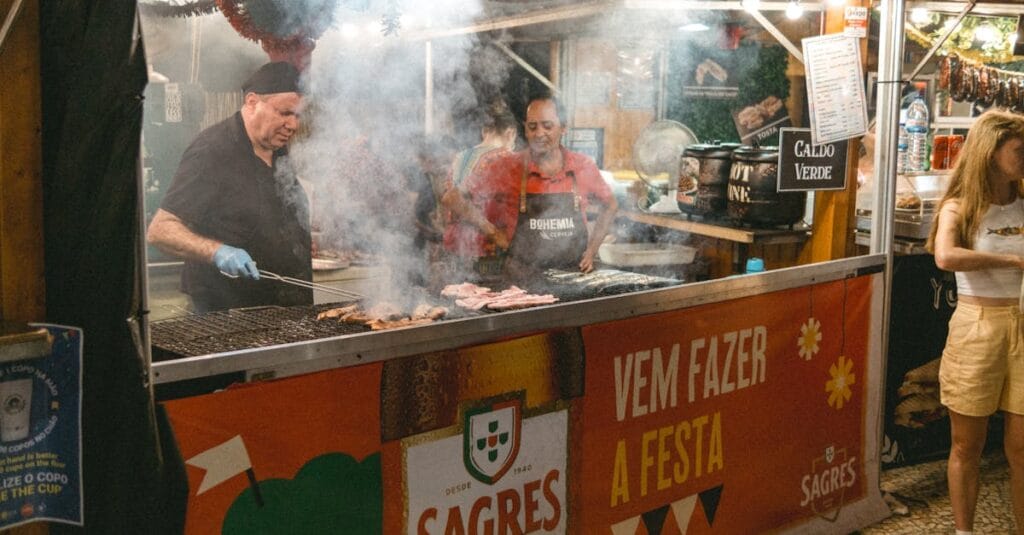 Street food vendors grilling meats at a lively night market in Lisbon, Portugal. A vibrant evening scene.
