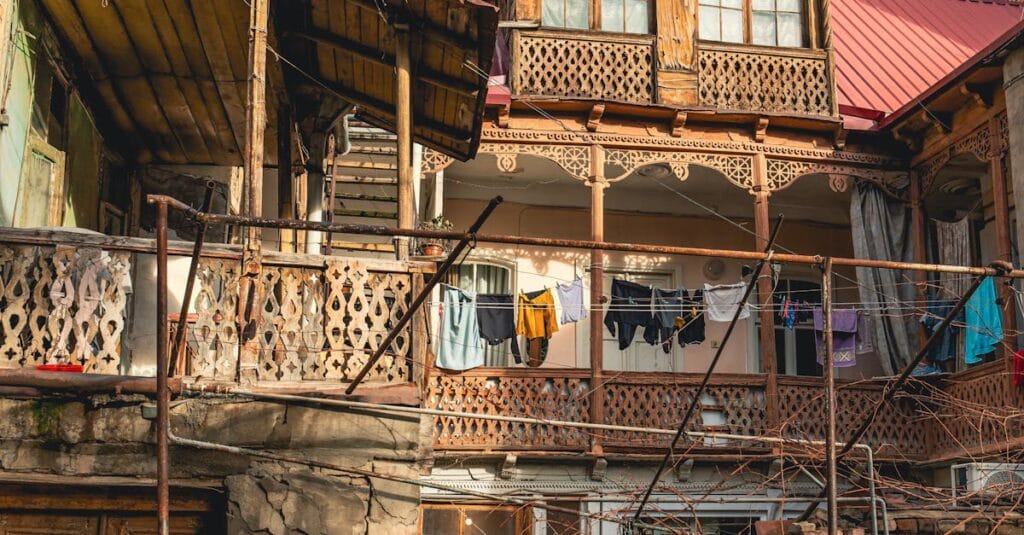 Rustic wooden balcony with hanging clothes in Tbilisi, illustrating traditional Georgian architecture.