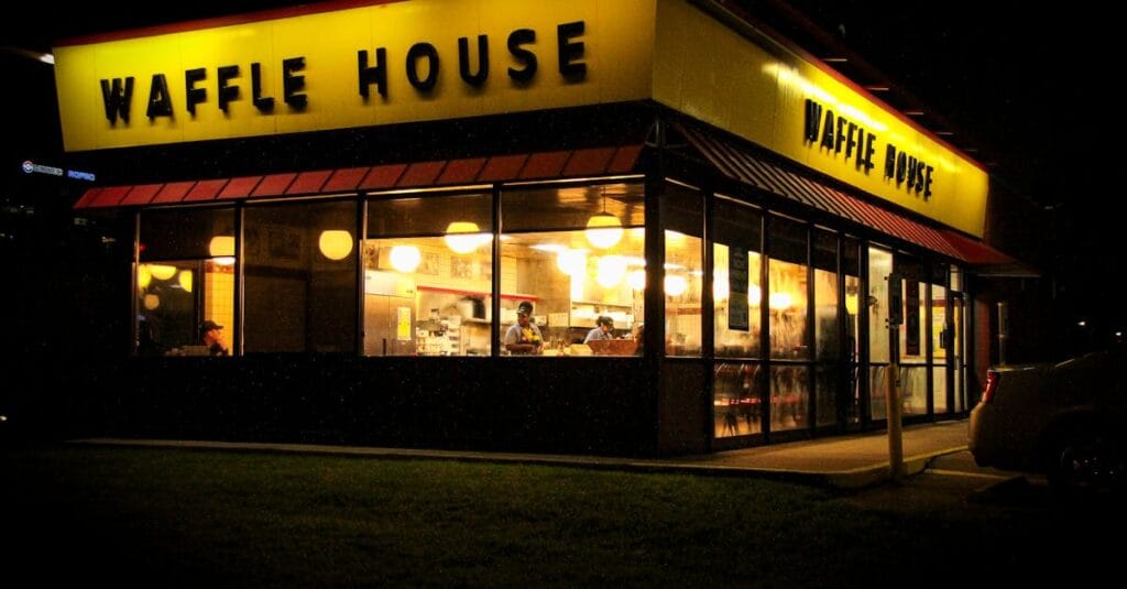 Evening view of Waffle House with bright lights in Houston, Texas.