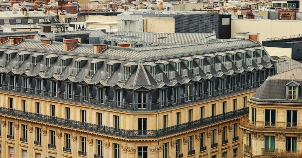 Aerial view of Paris streets and buildings with Eiffel Tower in the background.
