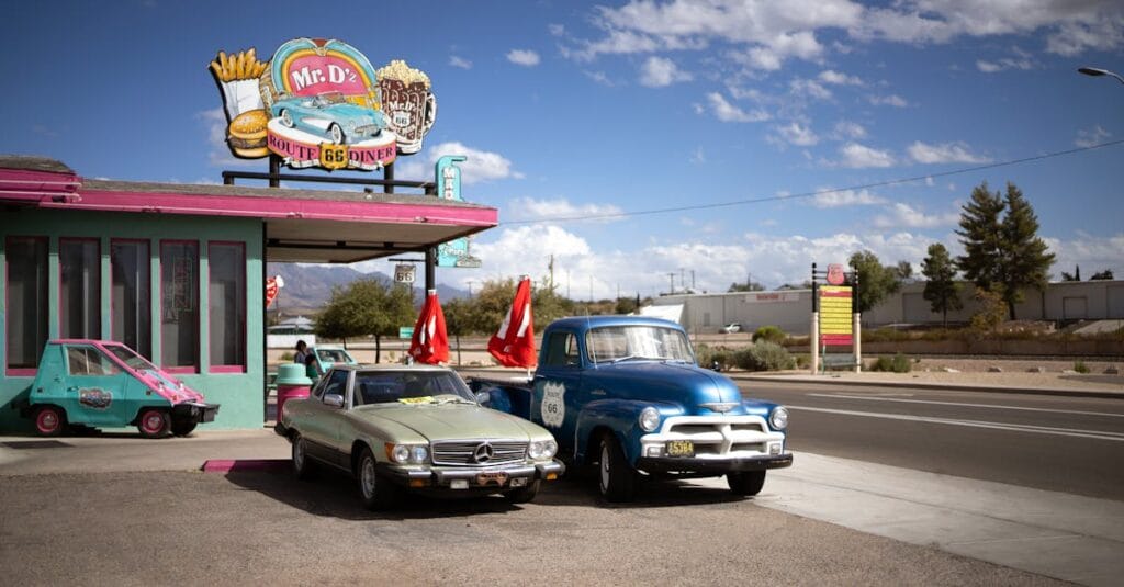Vintage cars parked outside Mr. D's Route 66 Diner under a bright blue sky.