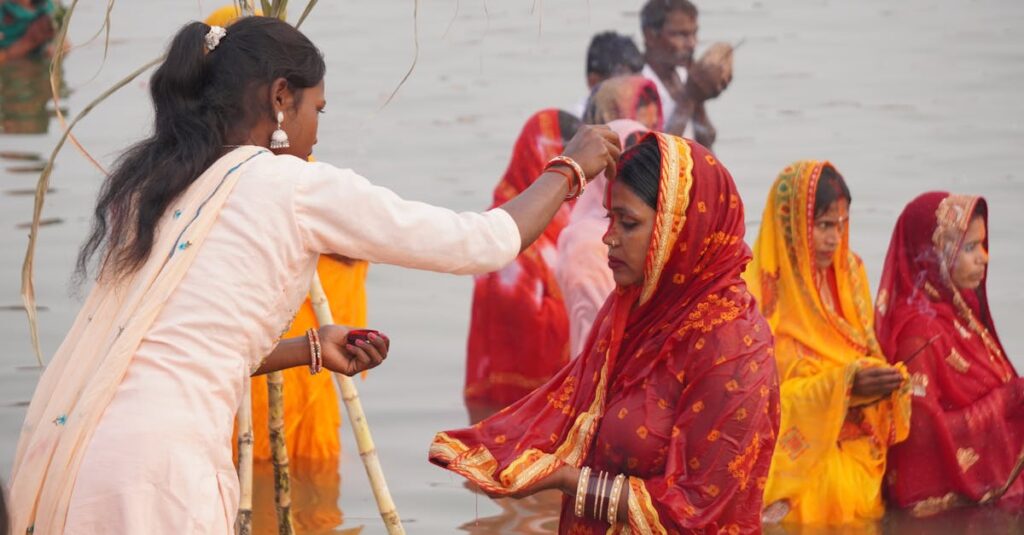 Women in vibrant sarees performing a religious ritual in the river.