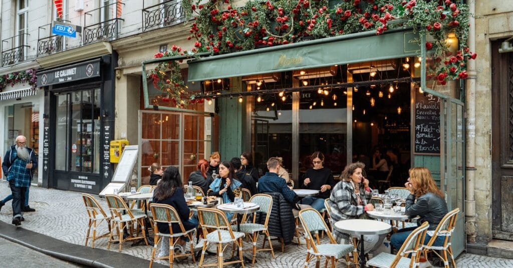 A lively street scene of a Parisian cafe with vibrant outdoor ambiance and dining.