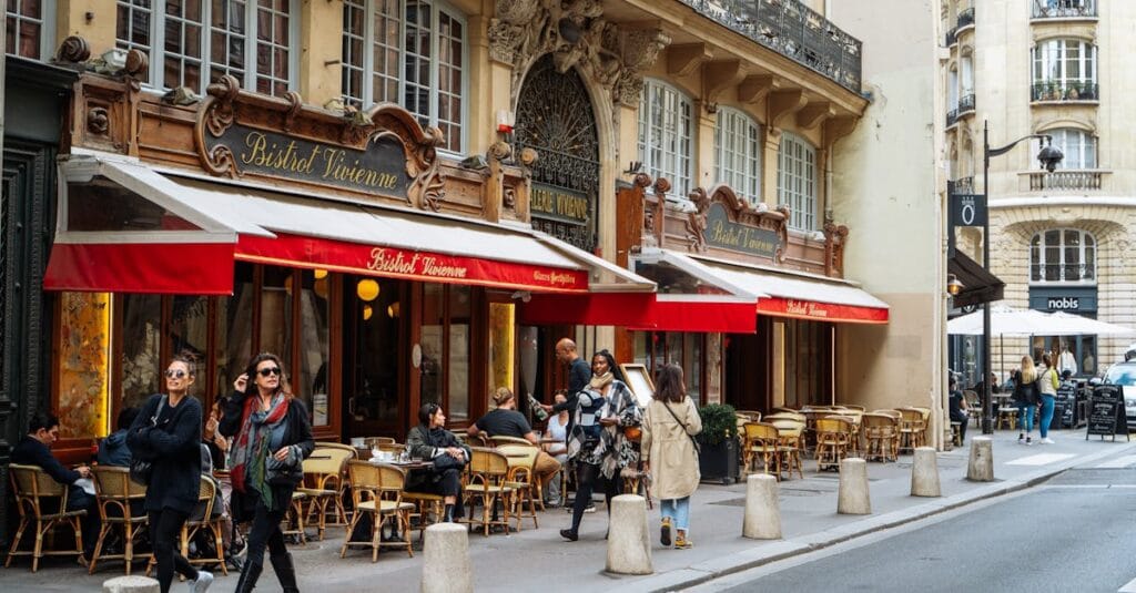 A classic Parisian bistro with outdoor seating and vibrant street life in Paris, France.