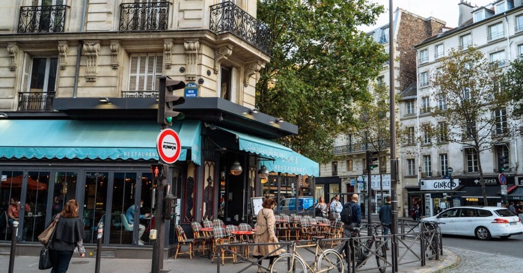 A scenic Paris café on a cobblestone street corner, capturing classic architecture and local life.