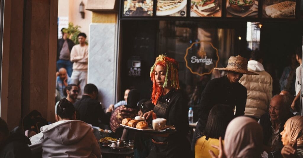 Vibrant cafe in Agadir with diverse crowd and lively atmosphere.