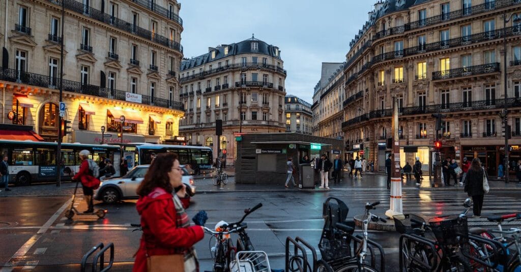 A busy Paris street intersection at twilight with elegant architecture and vibrant city life.