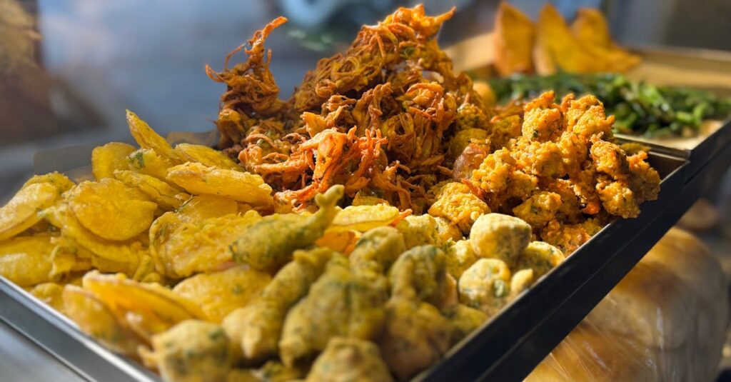 A vibrant display of assorted Indian street food snacks in Mumbai, featuring pakora and bhajia.