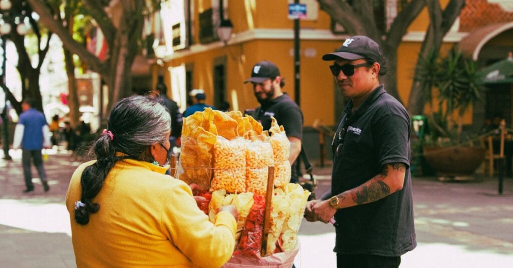A street vendor in Puebla, Mexico, selling snacks to customers in a bustling plaza.