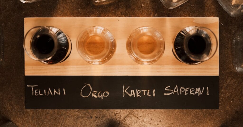 A wine flight featuring four Georgian wines on a wooden board in a restaurant setting.