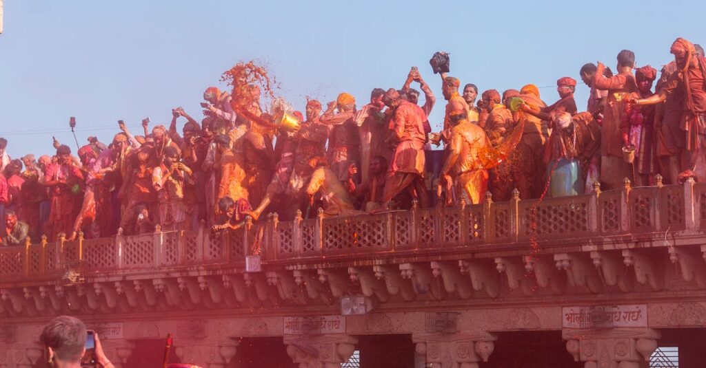 Crowds celebrate Holi with vibrant colors at Nandgaon temple in India.