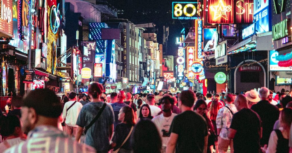 Bustling street with neon lights and crowds enjoying Bangkok's lively nightlife.