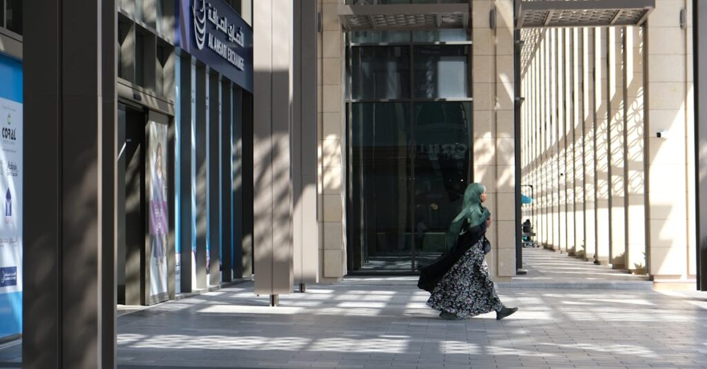 A woman in traditional attire walks in front of the Al Ansari Exchange building in downtown Dubai, UAE.