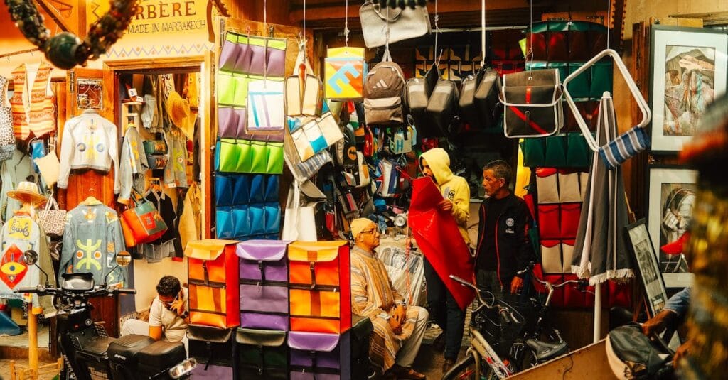 Colorful market stall in Marrakech medina displaying textiles and crafts, capturing vibrant local culture.