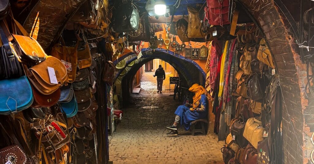 Explore the bustling souks of Marrakech's Medina with colorful bags and crafts.