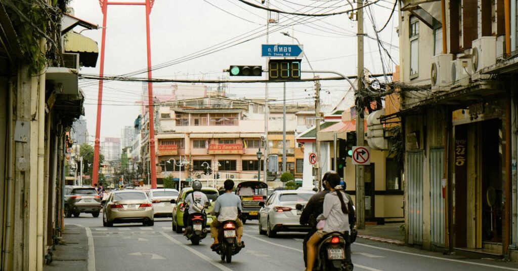 Motorcycles and cars on a city street with the Giant Swing in Bangkok, Thailand.