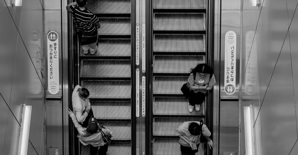 Black and white view of people on an escalator in Setagaya City, Tokyo, highlighting daily urban life.