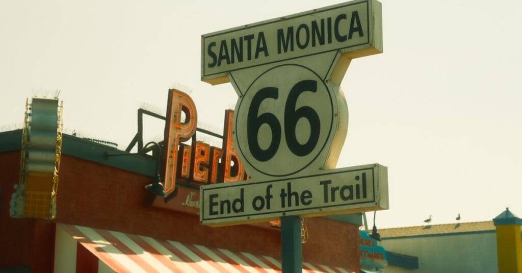Iconic Route 66 end sign at Santa Monica Pier captured under a sunny sky.