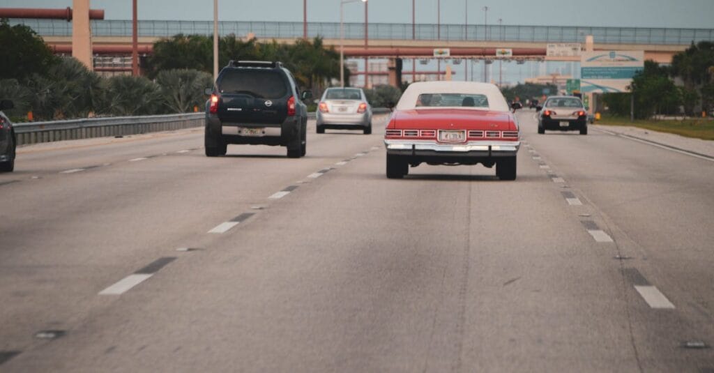 Highway traffic scene with classic car in Miami, Florida, showcasing urban travel atmosphere.