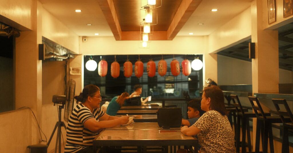 Warm ambiance inside a Japanese restaurant with red lanterns and patrons dining.