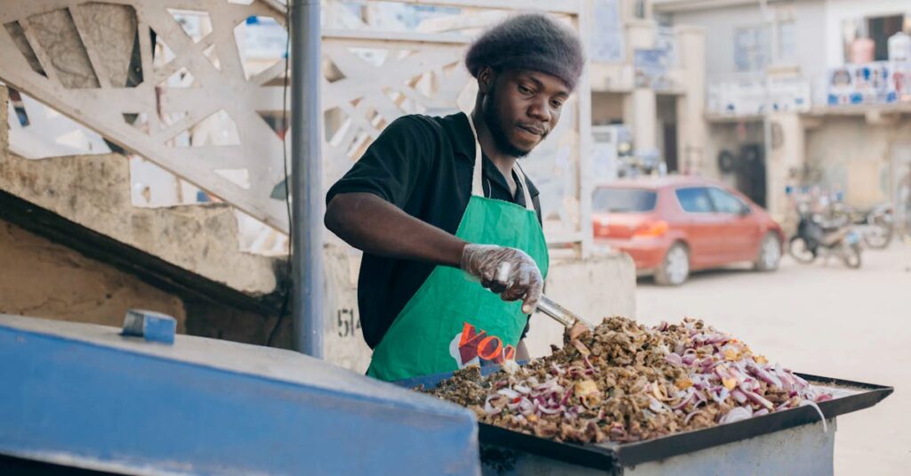 Street vendor preparing jollof rice on a busy urban street, showcasing culinary culture.