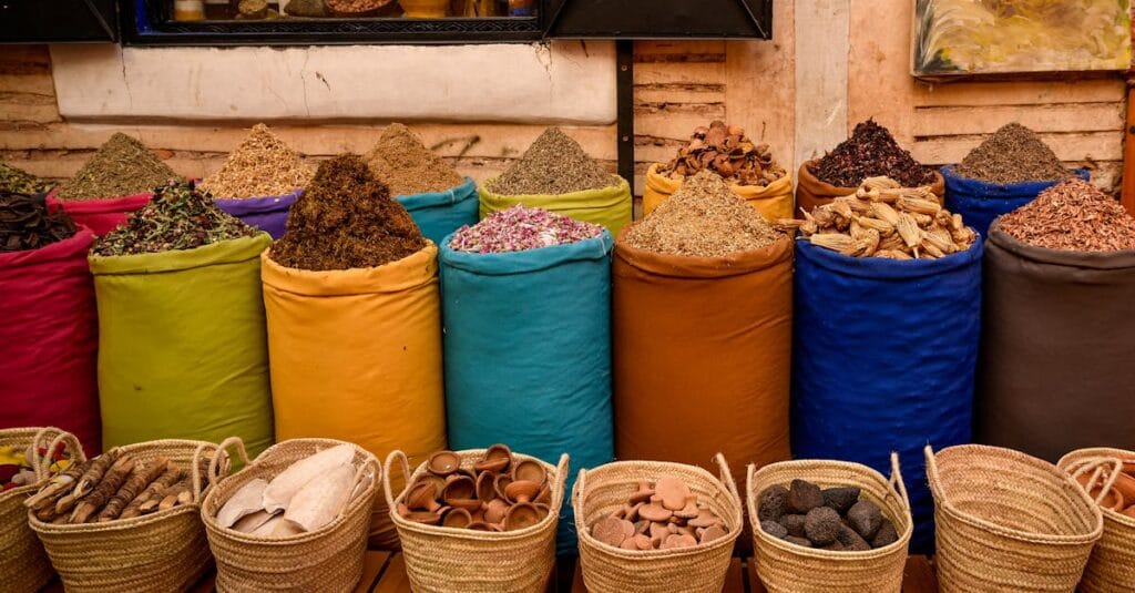 Colorful spice sacks in a Marrakesh souk depicting Moroccan culture.