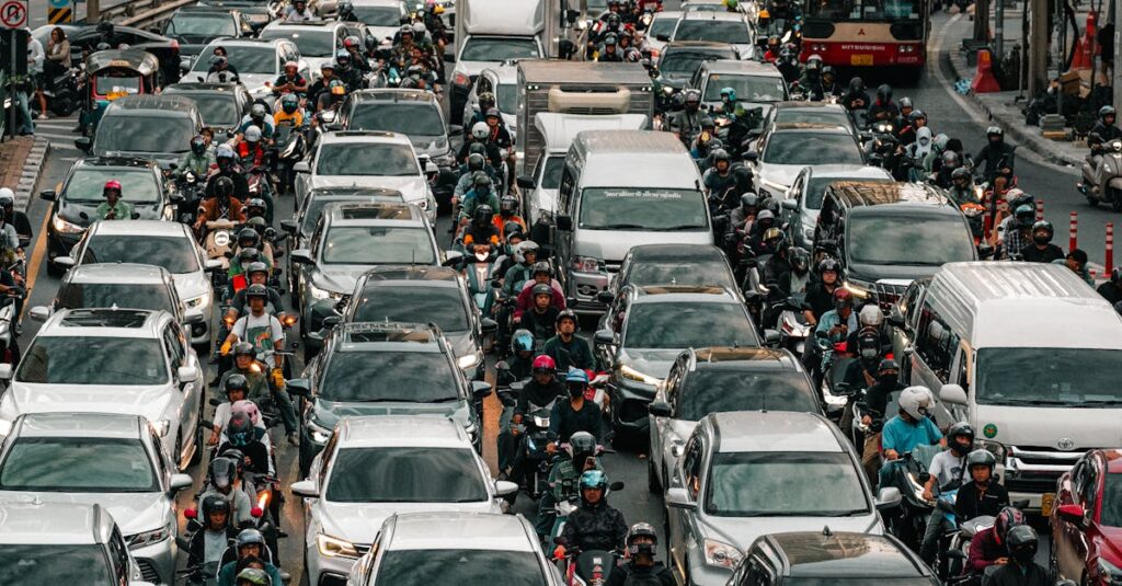 Aerial view of heavy traffic congestion, capturing cars, motorcycles, and people on a bustling city street during the day.