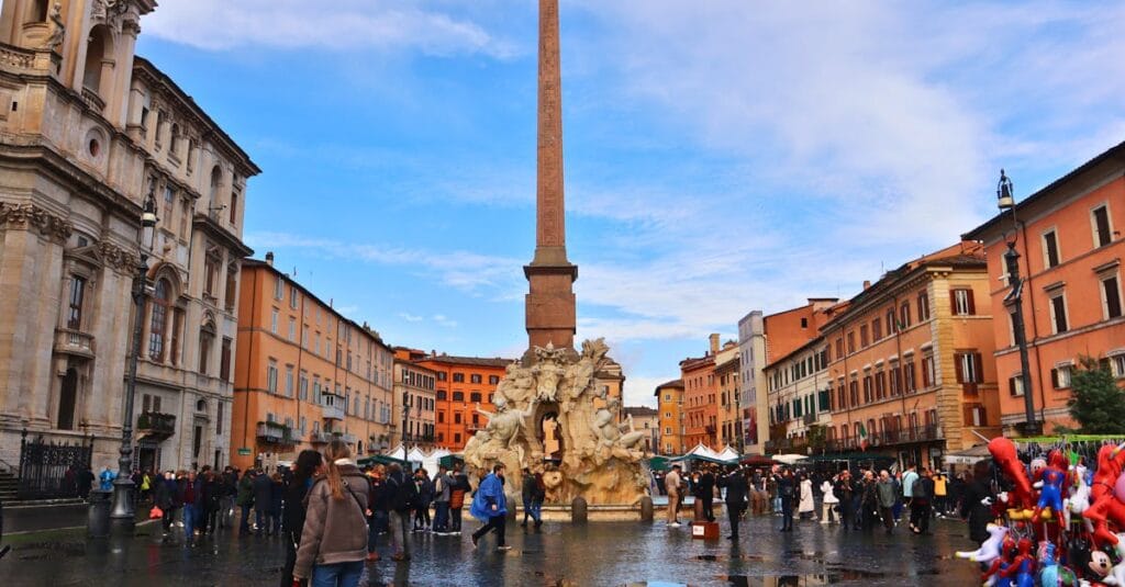 A bustling scene of Piazza Navona with the iconic Fountain of the Four Rivers in Rome, Italy.