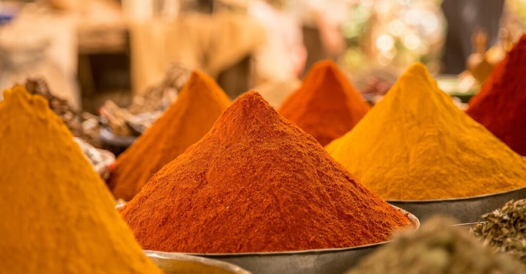 A close-up view of colorful powdered spices on display at a market stall.