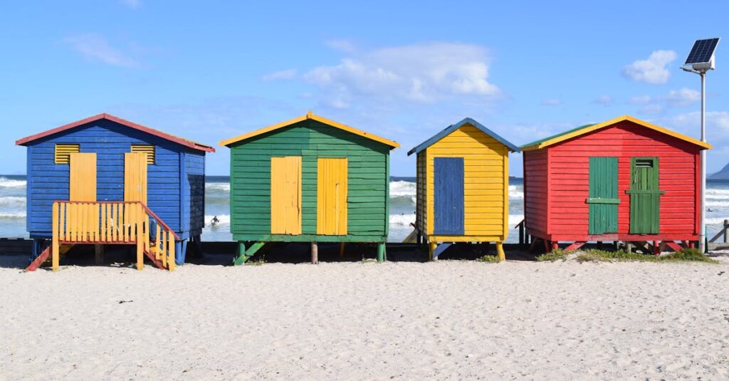 Vibrant beach huts on Muizenberg Beach, Cape Town, perfect for a summer travel escape.