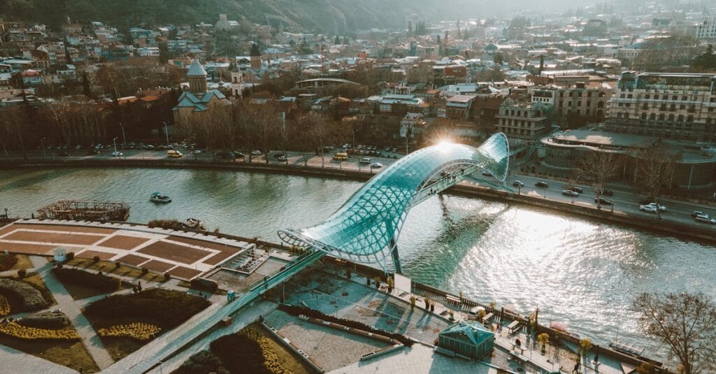 Scenic aerial shot of Tbilisi showcasing the Bridge of Peace over the Kura River.