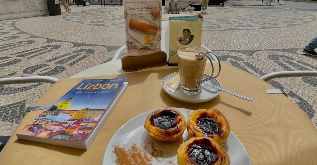 Savoring Pastéis de Nata with coffee in a Lisbon café, with iconic tram in the backdrop.