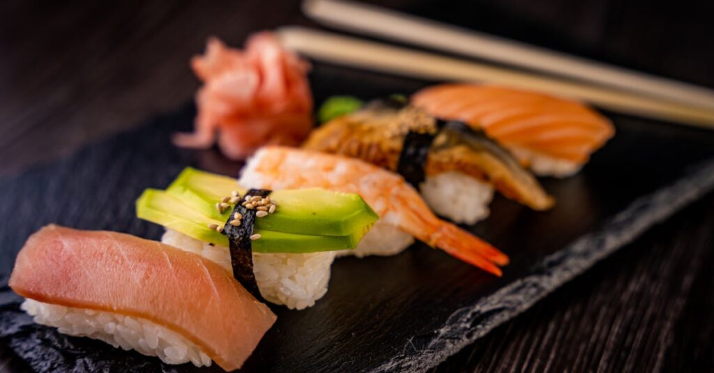 A variety of nigiri sushi including salmon, tuna, shrimp, and avocado on slate plate.
