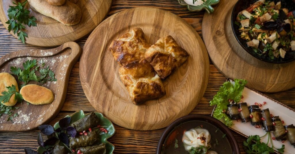 A variety of traditional Georgian dishes displayed on a wooden table with fresh herbs.